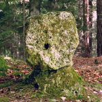 Alter Steinquader mit Loch auf Sockel im Wald